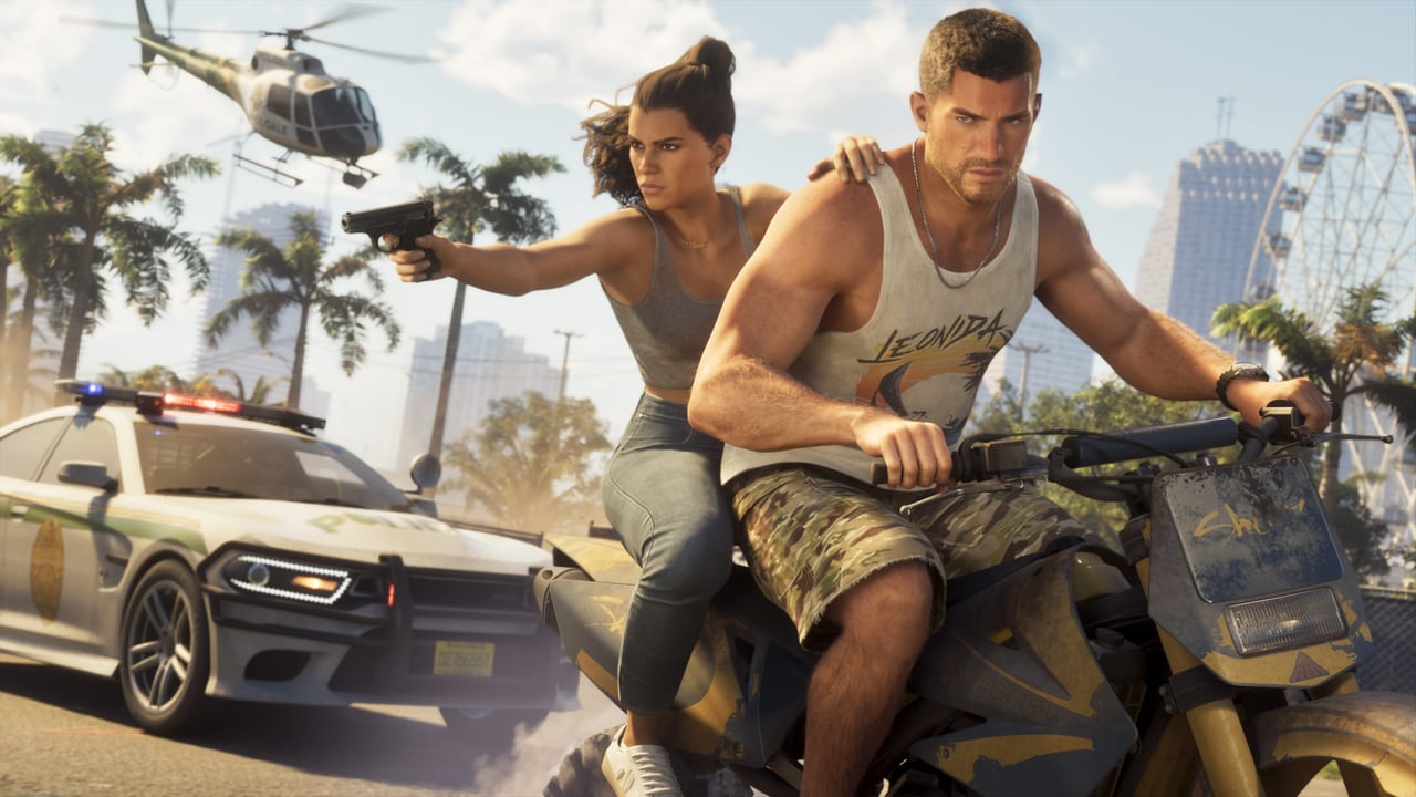 Official GTA VI screenshot of Jason riding a dirt bike with Lucia behind him aiming a pistol, a police car and a helicopter in pursuit.